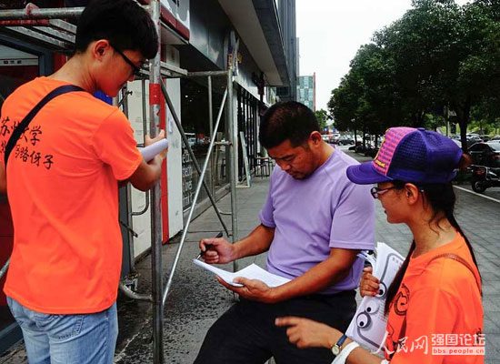 志愿者向市民分發(fā)文明出行宣傳單。